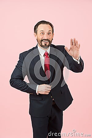 Happy businessman saluting on pastel pink background. A handsome businessman is greeting or saying hello his partners Stock Photo
