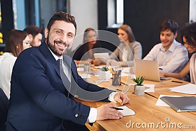 Happy businessman smiling to camera with colleagues on background Stock Photo