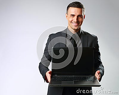 Happy businessman standing with laptop Stock Photo
