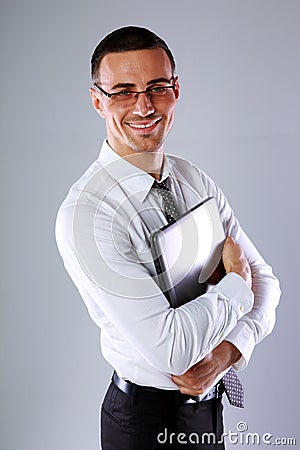 Happy businessman standing with laptop Stock Photo