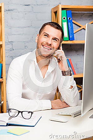 Happy businessman talking on mobile phone while working with PC computer Stock Photo