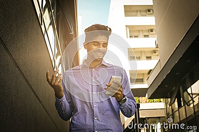 Businessman walking trough street and typing on smart phon Stock Photo