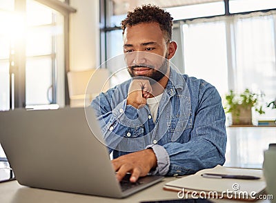 Happy businessman working on his laptop at home. Handsome businessman reading an email on his laptop at home. Freelance Stock Photo