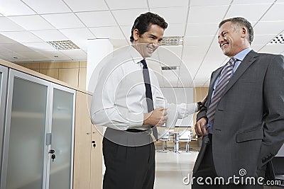Happy Businessmen Communicating In Office Stock Photo