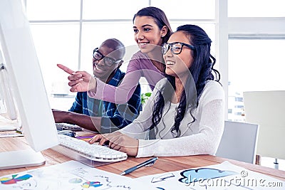 Happy businesswoman explaning to colleagues on computer Stock Photo
