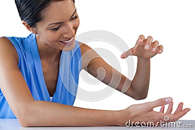 Happy businesswoman holding something while sitting at table Stock Photo