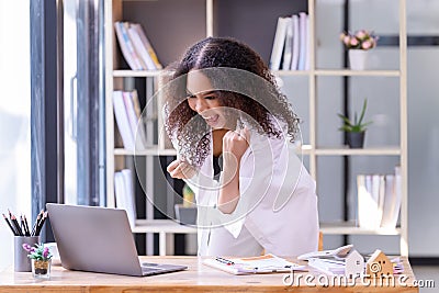 Happy businesswoman laughing with joy at the good news about work at the workplace, gladly looking at laptop screen, feeling Stock Photo