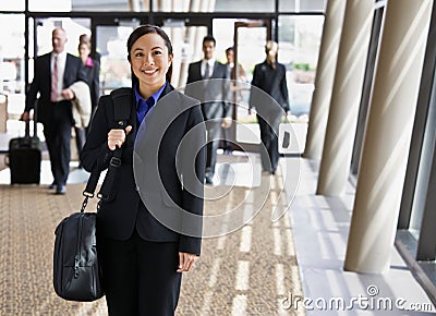 Happy businesswoman in suit holding briefcase Stock Photo