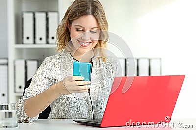 Businesswoman using multiple devices at office Stock Photo