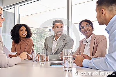 Happy busy diverse executive board business team at office meeting table. Stock Photo