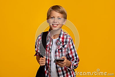 Happy calm caucasian teen boy pupil with backpack and smartphone ready to learn, chatting with friend Stock Photo