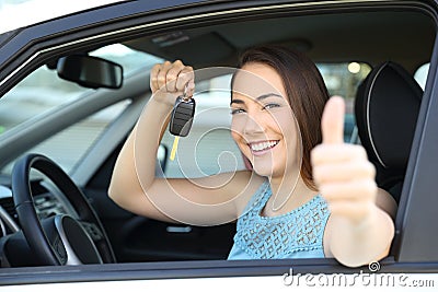 Happy car owner with a key and thumbs up Stock Photo