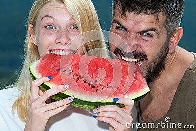 Happy carefree couple eat watermelon. Vitamins and healthy concept. Enjoying a watermelon. Couple friends eating a Stock Photo