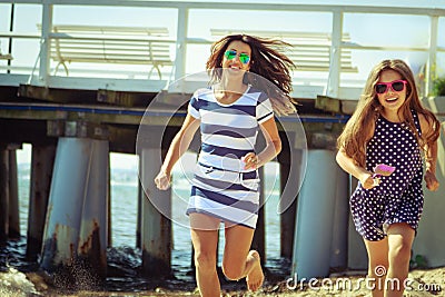 Happy carefree family running on beach at sea. Stock Photo