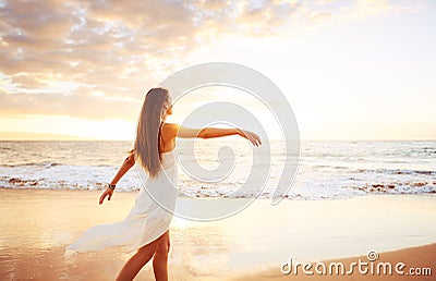 Happy Carefree Woman on the Beach at Sunset Stock Photo