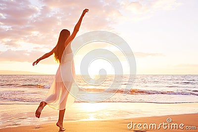 Happy Carefree Woman Dancing on the Beach at Sunset Stock Photo