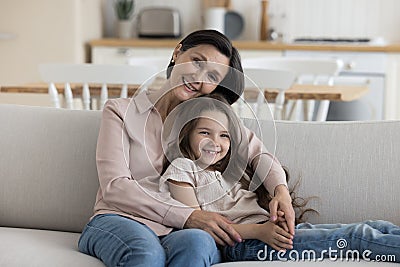 Happy caring grandma hugging positive adorable little kid girl Stock Photo