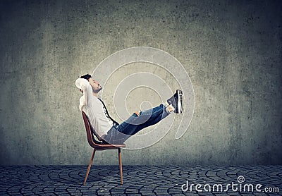 Happy casual business man sitting on chair with feet up relaxing Stock Photo