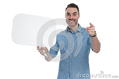 Happy casual holding blank speech bubble and pointing forward Stock Photo