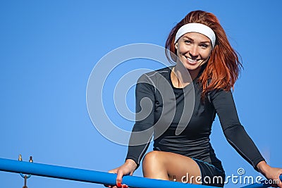 Happy Caucasian Red Haired Sportswoman Posing on Parallel Bars Stock Photo