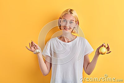 Happy cheerful blonde woman showing garlic and onion Stock Photo