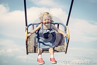 Happy cheerful child girl fun swinging sky happy carefree childhood Stock Photo