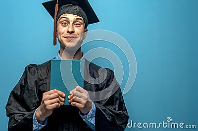 Happy cheerful Graduate man holding blue diploma Stock Photo