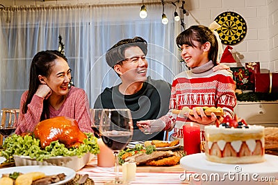 Happy and Cheerful group of extended Asian family talking and smiling during Christmas dinner at home. Celebration holiday Stock Photo