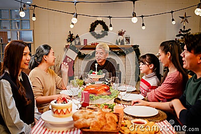 Happy and Cheerful group of extended Asian family talking and smiling during Christmas dinner at home. Celebration holiday Stock Photo