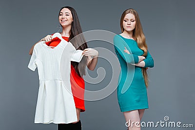 Happy cheerful young woman and envious angry female on shopping Stock Photo