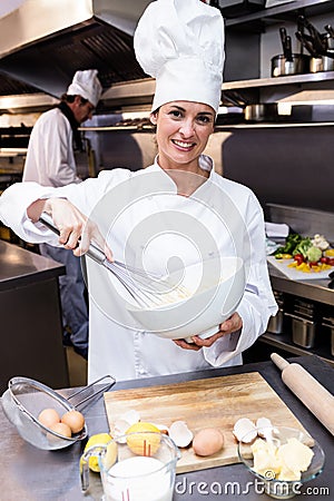 Happy chef whisking bowl of eggs Stock Photo