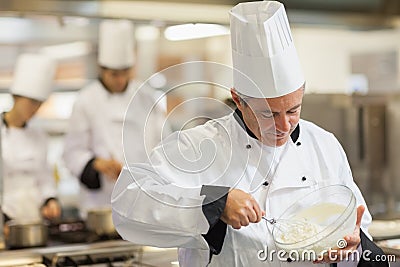 Happy chef whisking cream Stock Photo