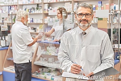 Happy chemist smiling, posing in pharmacy. Stock Photo