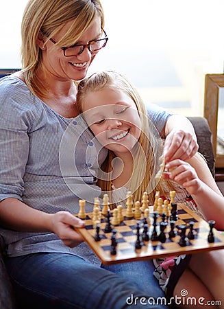 Happy, chess and a mother and child with a game for competition, strategy or thinking. Smile, family and a mom, girl or Stock Photo