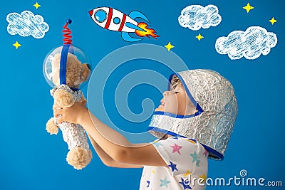 Happy child astronaut playing with teddy bear Stock Photo