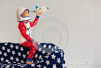 Happy child astronaut playing with toy rocket at home Stock Photo
