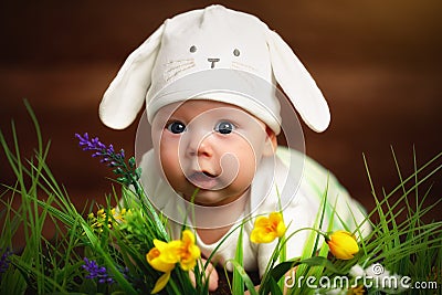 Happy child baby dressed as the Easter bunny rabbit on the grass Stock Photo