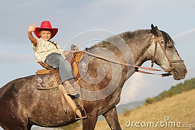 Happy child boy riding horse on nature Stock Photo