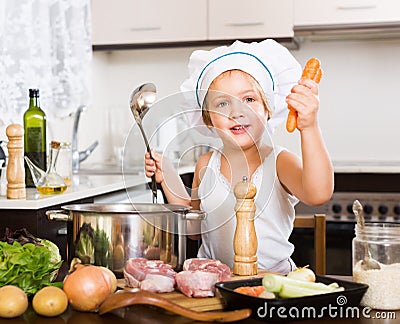 Happy child cooking soup with vegetables Stock Photo