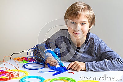 Happy child creating new 3d object with 3d printing pen Stock Photo