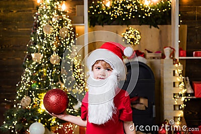 Happy child decorating Christmas tree. Happy little child dressed in winter clothing think about Santa near Christmas Stock Photo