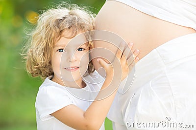 Happy child embraces belly Stock Photo