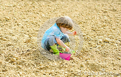 Happy child gardener. botanic worker. Spring. earth day. new life. summer farm. small kid planting a flower. ecology Stock Photo