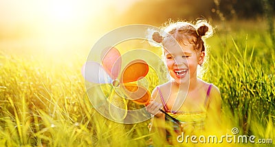 Happy child girl with colorful pinwheel windmill in summer Stock Photo