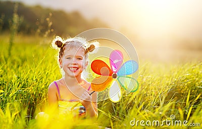 Happy child girl with colorful pinwheel windmill in summer Stock Photo