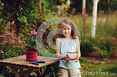 happy child girl decorating evening summer garden with candle holder Stock Photo