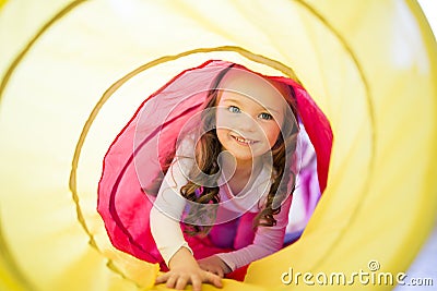 Happy child girl plays indoor in a tunnel Stock Photo