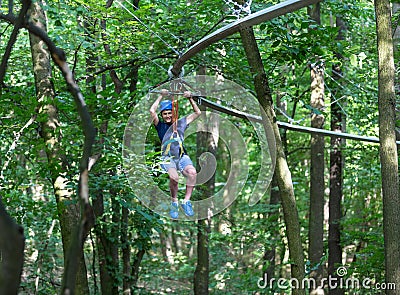 Happy child, healthy teenager in helmet enjoys activity in a climbing adventure rope park Stock Photo