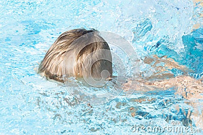 Child learn to swim, dive in blue pool with fun - jumping deep down underwater with splashes Stock Photo