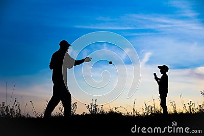A Happy child with parent playing baseball concept in park in nature Stock Photo